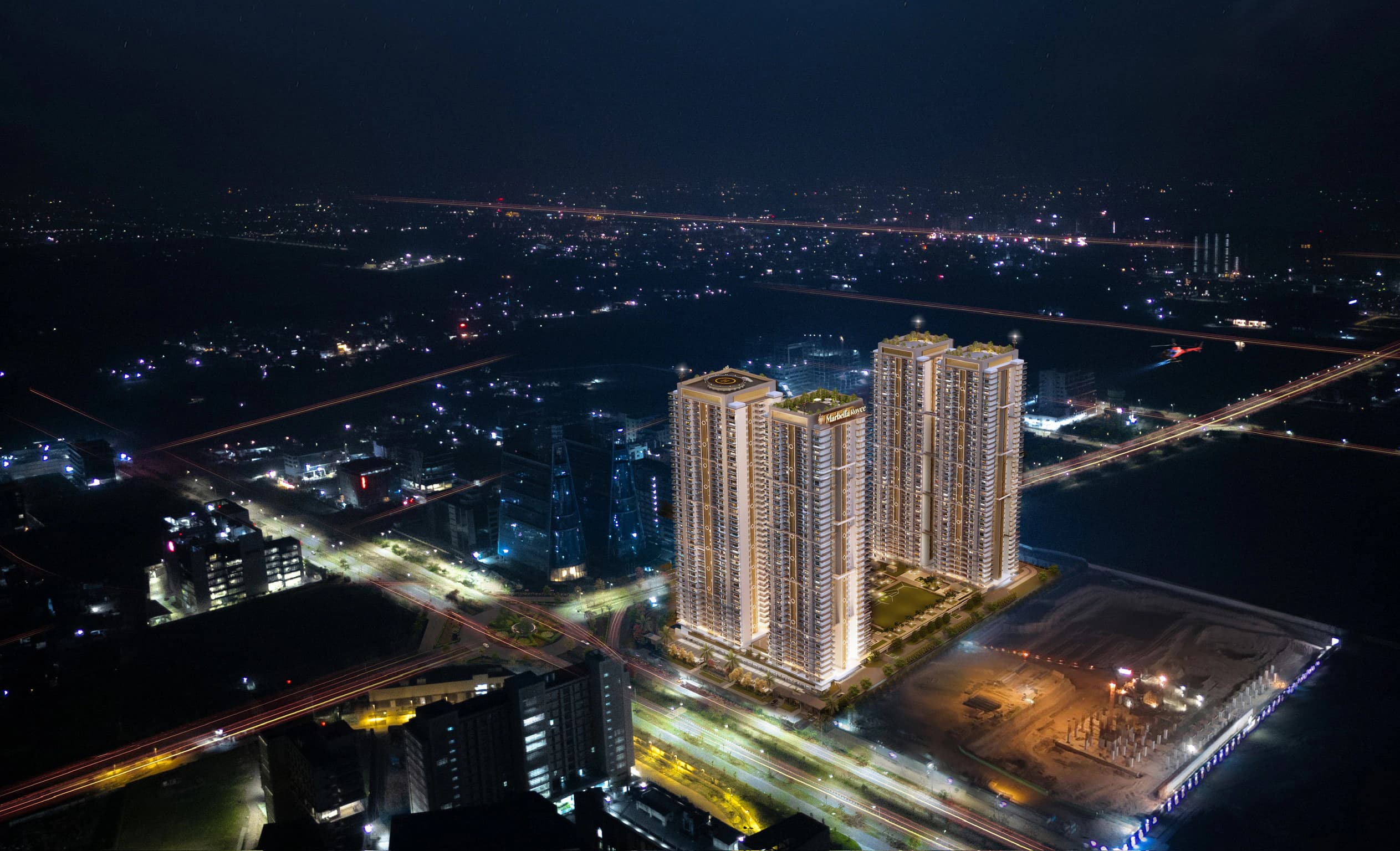 Marbella Royce residential high-rise towers illuminated against the city at night